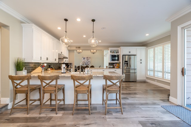 a modern white kitchen with a large island
